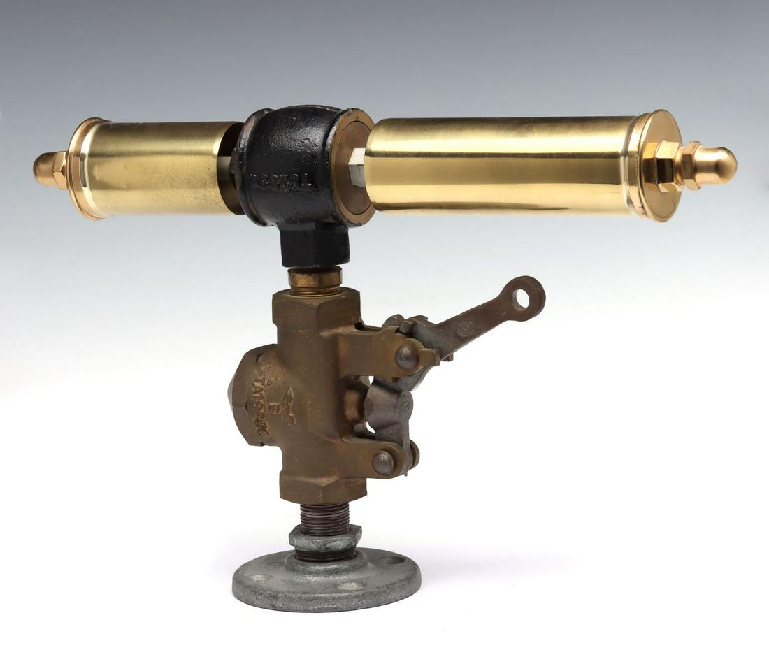 A GONG WHISTLE WITH TWO SINGLE CHIME BRASS BELLS: The two whistles on a common horizontal axis above a brass valve with side lever, no maker's markings found. Valve plate to top measures 8.5 and 6 inches. Diameter measures 2 inches. Overall height is