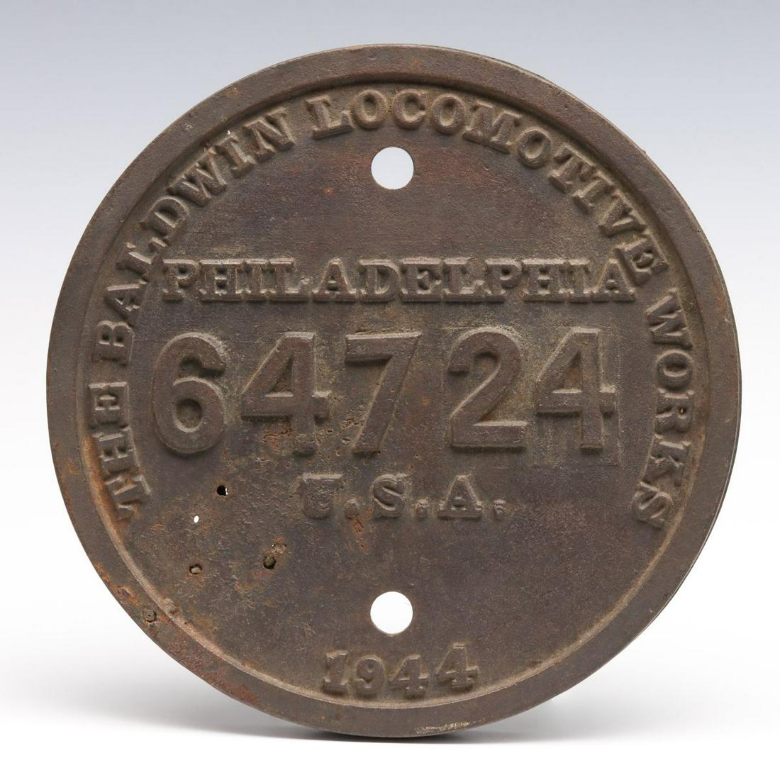 A BALDWIN BUILDER'S PLATE FOR L&N BIG EMMA NO. 1965: The circular cast iron builder's plate with embossed lettering and numerals within a pronounced outer rim, for Louisville and Nashville railroad Big Emma 2-8-4 locomotive number 1965. Measures 9.25 x 