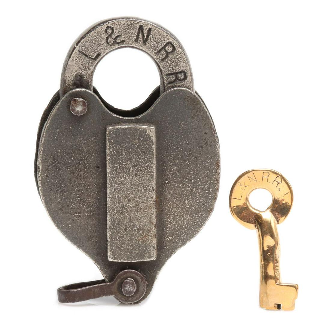 A CAST IRON HEART SHAPE PADLOCK FOR L & N RAILROAD: The iron lock with brass key, each bearing the call letters of the Louisville and Nashville railroad. Measures 4 x 2.75 x 1 inch. We happily provide seamless in-house packing and shipping services on 