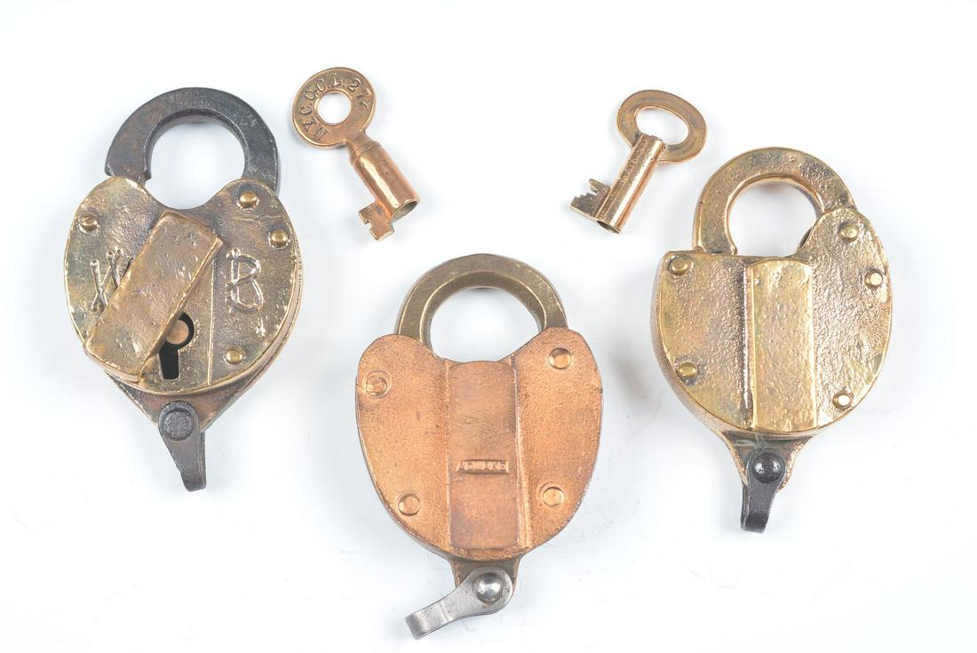 CAST BRASS PADLOCKS WITH RAILROAD MARKINGS: Three padlocks include: Raised lettering T&OCRR on the body for the Toledo & Ohio Central Railroad, marked TRACK on the shackle, signed Wilson Bohannan, key stamped N.Y.C.O.C.L.27; An Adlake switch lo