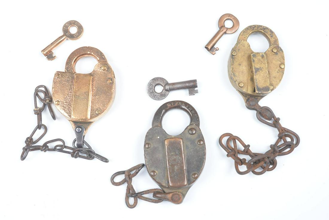 CAST BRASS PADLOCKS WITH RAILROAD MARKINGS: Three railroad padlocks include: Raised lettering CM&StPRR on the body for the Chicago, Milwaukee & St Paul Railroad, key stamped SM&PduCRy; A heart-shaped lock stamped ST.J&GIRR on the shackle for th