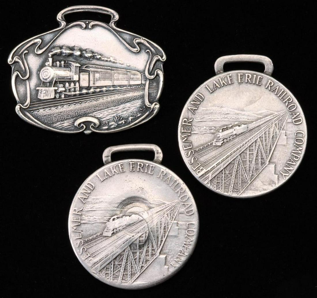 A PAIR OF STERLING SILVER SERVICE FOBS FOR B.&L.E.RR.: Two engraved service fobs for one 'GLEN M. WOOD' from the Bessemer and Lake Erie Railroad Company for 35 and 40 'Years of Loyal Service,' noting that the 40 year fob has been struck dead center by a b