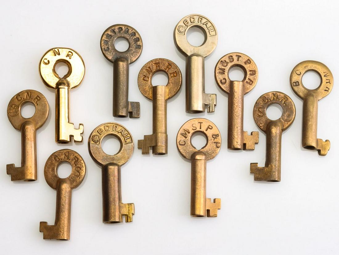 A COLLECTION OF SWITCH KEYS WITH RAILROAD MARKINGS: Eleven brass railroad switch keys stamped CNR for Canadian National Railway (x4), CMSTP&P for Chicago, Milwaukee, St. Paul and Pacific Railroad (x3), BC RAIL (x2), BC NRR and CNERR. We happily provide