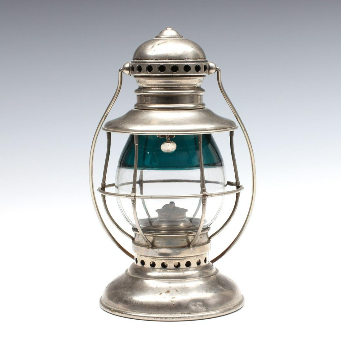 AN ADAMS & WESTLAKE CONDUCTORS LANTERN WITH GREEN GLOBE: The conductor's's or presentation lantern having nickel plated frame, hoop bail handle with wear, fused glass two-color globe as found and maker's mark on the base. We happily provide seamless in-hous