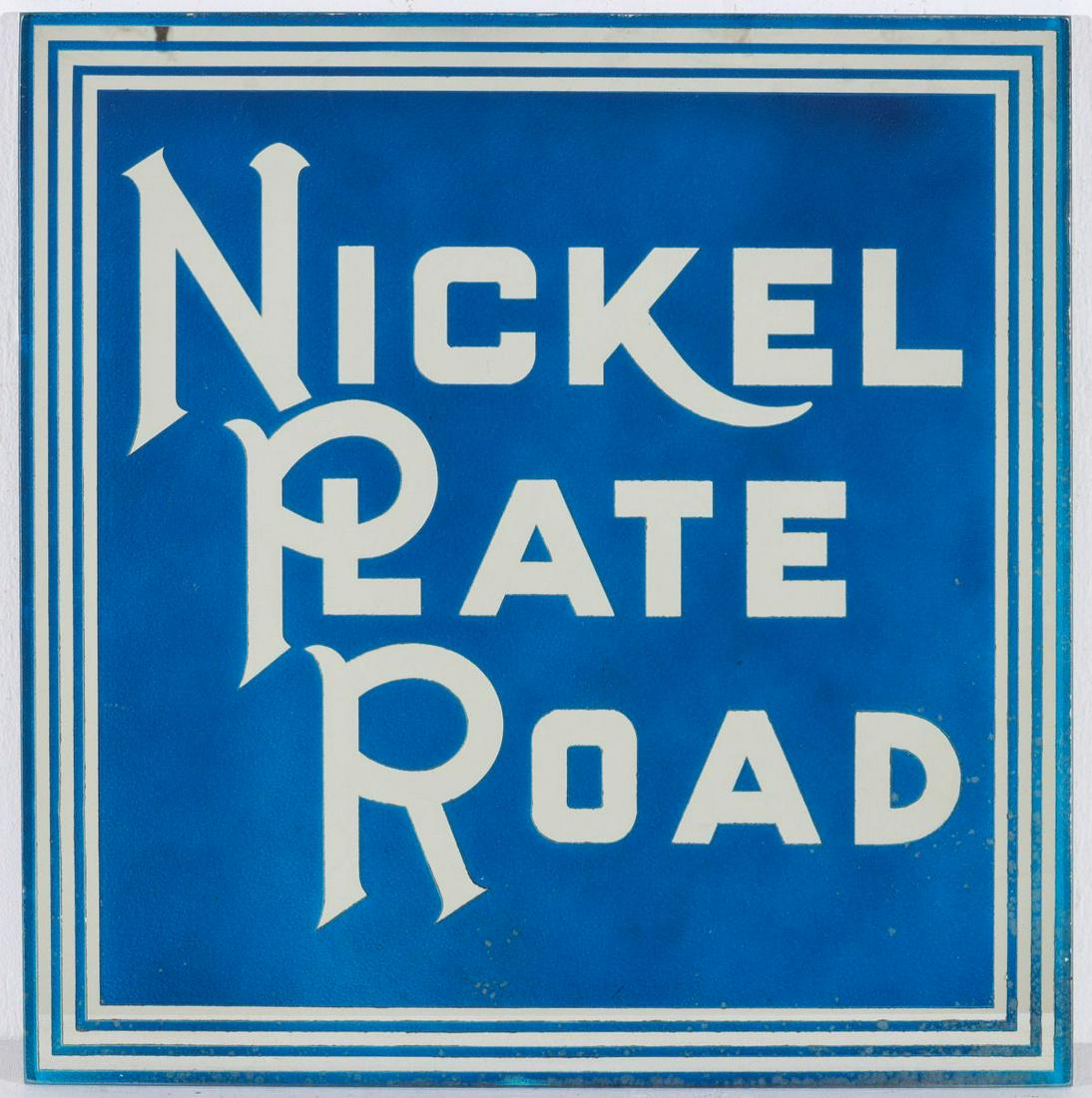 A NICKEL PLATE ROAD REVERSE PAINTED AND ETCHED GLASS: The square plate glass sign with stylized block letter font acid cut in reverse on the back side of the glass plate framed in three parallel lines, blue painted ground with white lettering and framing
