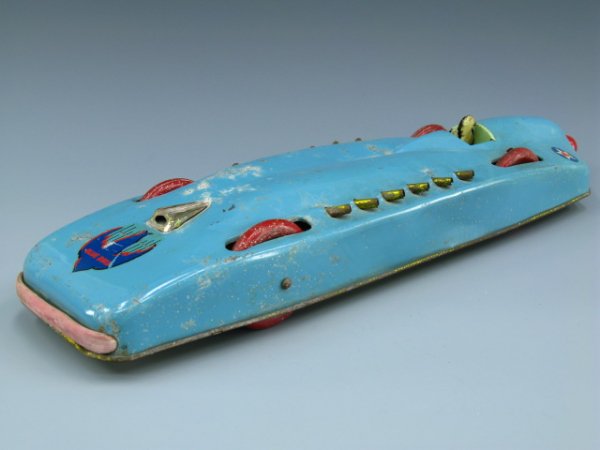 BLUE BIRD FRICTION TIN TOY CAR CIRCA 1930'S: Measures 22 inches in length, light blue paint with star decals toward back, Blue Bird decal to front, four large red wheels, 12 exhaust pipes to sides, red ball pull knob to back still powers wheels.