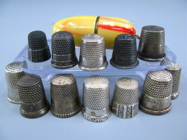 LOT OF STERLING THIMBLES AND CASE: 12 thimbles and one egg-shaped enameled case, 8 marked sterling, thimble case marked MADE IN GERMANY, thimbles weigh 1.4 oz.