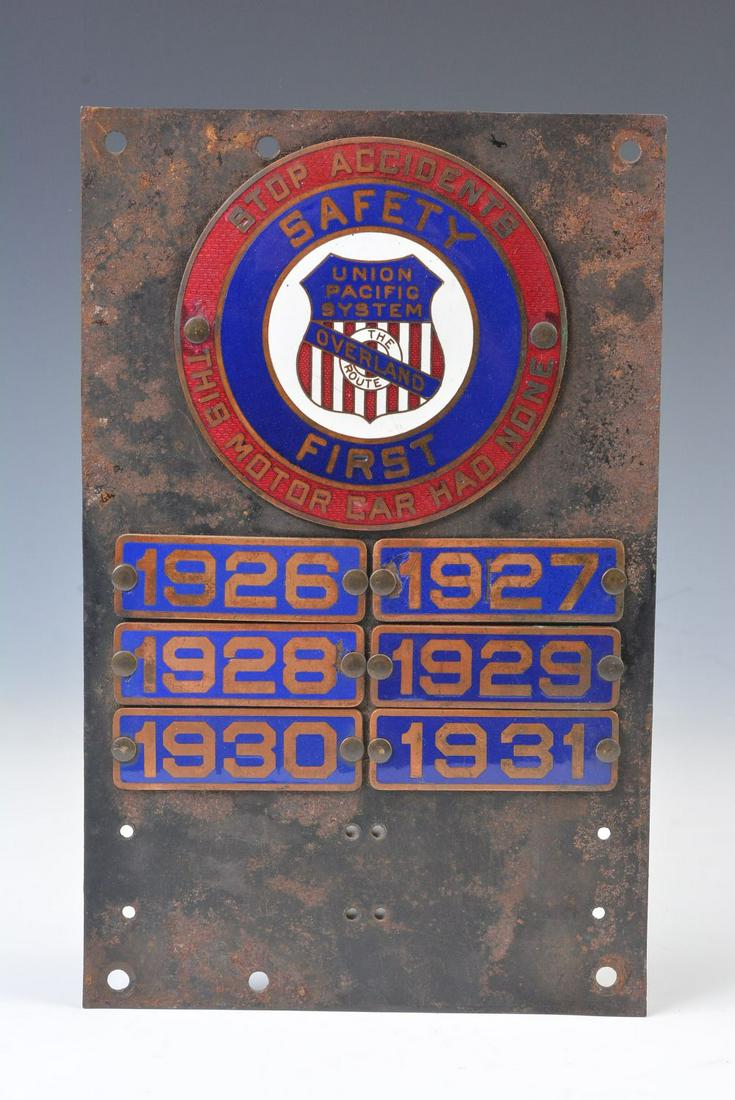 A UP RR OVERLAND ROUTE ENAMEL SAFETY PLAQUE C. 1914: The sheet iron tablet mounted with large circular copper plaque in red, white and blue fired-on enamels with exposed copper lettering of STOP ACCIDENTS THIS MOTOR CAR HAS NONE - SAFETY FIRST - centere