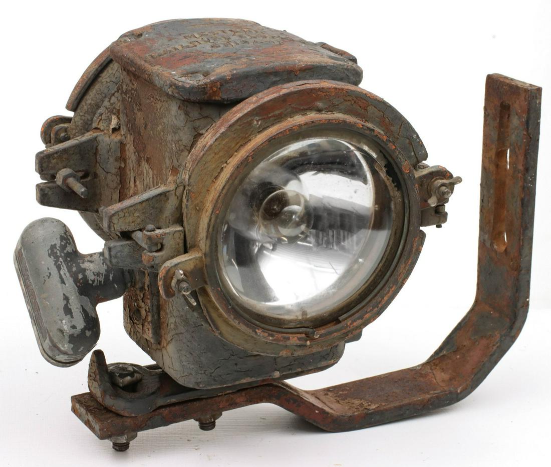 A WESTERN RAILROAD SUPPLY TRAIN ORDER SIGNAL LIGHT: The adjustable cast iron housing train order lamp number 1569 as pictured on plate L70 of the company catalog. Light with the bracket measures 14 x 10 inches. We happily provide seamless in-house pack