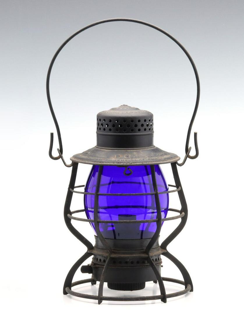 A TALL RAILROAD LANTERN EMBOSSED A.C.L WITH BLUE GLOBE: The wire frame with embossed maker's mark of ''KEYSTONE LANTERN CO PHILADELPHIA PA USA and embossed railroad marking of A. C. L. on the shoulder for Atlantic Coast Line, tall, plain blue glass globe w