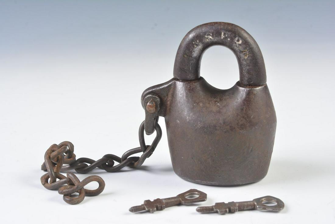 AN A.T.&S.F. RAILROAD CAST IRON PADLOCK WITH KEYS: The 'Scandinavian style' iron padlock stamped A.T.&S.F.R.R. on the shackle, two keys. Measures 3 inches. We happily provide seamless in-house packing and shipping services on nearly everything we