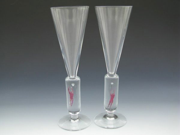 PAIR OF KOSTA BODA MILLENNIUM FLUTES: Each measures 10.25 inches tall, clear crystal with red foil leaping man inside lower stem with bubble 'basketball' suspended above him, designed by Bertil Vallien.