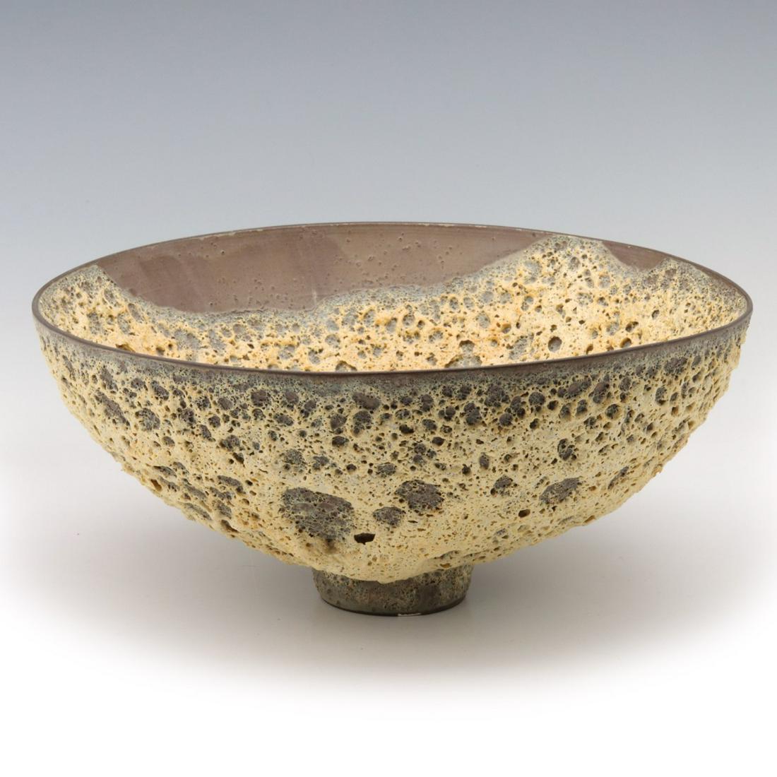 JAMES LOVERA (1920-2015) CRATERED GLAZE BOWL: James Lovera (1920-2015) Late 20th Century. The deep rounded bowl on small pedestal foot glazed in creamy yellow deeply cratered glaze along with unglazed reserves, signed on the base. Measures 4.5 x