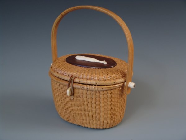 A NANTUCKET BASKET PURSE WITH WHALE: Nantucket basket purse with applied carved bone whale to top lid wood oval, carved bone swivels to sides and front latch, no lynch pin, formed wooden handle, etched "Hand Made for I. Magnin" to inside