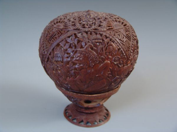 BALINESE CARVED WOOD GLOBE AND STAND: Two piece set with meticulously carved wood globe depicting various demons and dragons, plus intermeshed swastikas, flowers and other native motifs, with form fitted carved stand, also with flower mot