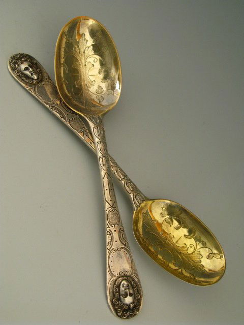 A PAIR 1789 PARIS SILVER SERVING SPOONS: A pair of spoons with broad engraving and portraits of perhaps Louis XIV at their tip. Each is hallmarks Paris 1789 and measures 8" long with a total weight for the two of 157 g. Included is a card fr