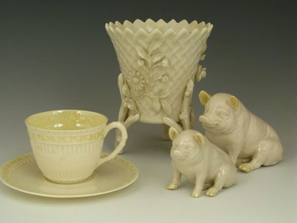 FOUR PIECE BELLEEK PORCELAIN FIGURES & VASE: Includes two green marked pigs, 3 x 4 and 2 x 3 inches, a demitasse cup and saucer, black marked, and a black marked basket vase with applied flowers and three twig footed base.
