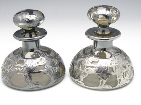 A PAIR OF STERLING SILVER OVERLAY COLOGNE BOTTLES: A pair of antique sterling silver overlay cologne bottles measuring 3 1/8" across bottom and 3 1/2" tall including stopper, Monogrammed.