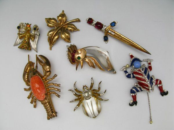 SEVEN PIECES OF COSTUME JEWELRY, TRIFARI +: Includes Trifari marked leaf, rooster, bug with 'sterling' marked frame, sword, plus an angel with 'sterling' marked wings, jester with pull chain, and a large lobster with inset stone and green glass
