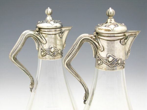 1903 SILVER MOUNTED YACHT CLUB CLARET JUGS: Matching pair of silver mounted clear glass jugs with .800 silver marked necks and hinged lids, maker marked M. Hansen, 38767, hand engraved "Kaiserlicher Yacht Club, Kiel, 26 Juni 1903" to the neck o