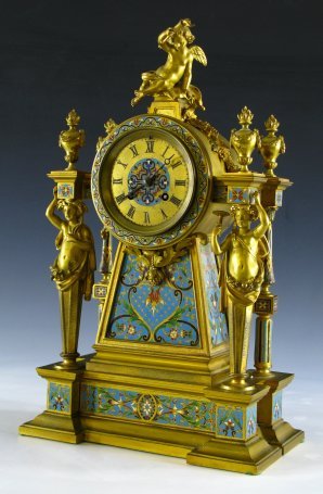 A CHAMPLEVE' & BRONZE DORE' CLOCK, JAPY FRERES: An exceptional 19th century bronze dore shelf clock with classical caryatid figures flanking a Champleve' enameled case topped by a cherub figure. The movement is marked M.K. with serial number 1280 a