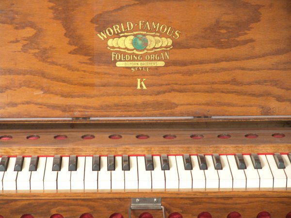 BILHORN FOLDING MISSIONARY ORGAN STYLE K: A neat circa 1930's folding pump organ, style K, measures approximately 10.5 x 18 x 30 inches when folded for transportation. Hinged keyboard access door, company logo decal inside, "Jesus Never Fails