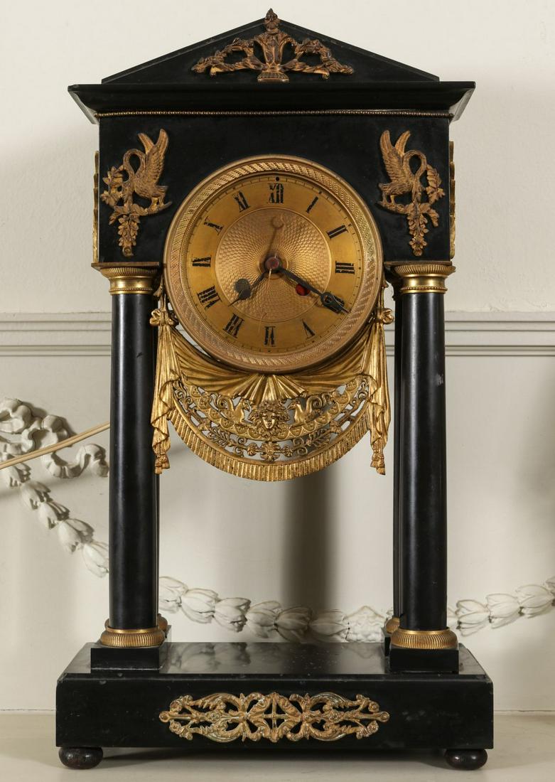 AN ALTERED 19TH C. LOUIS PHILLIPE PORTICO CLOCK: The ebonized case with cornice and pediment upon four columns, gilt bronze applications and engine turned dial with Roman numeral chapter ring, the movement is a 1940s electric replacement. Measures 1