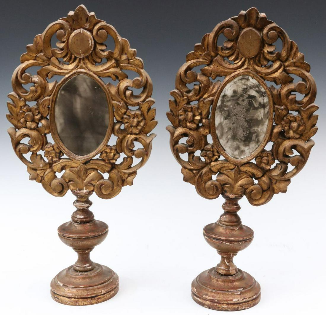 A PAIR 18TH/19TH C. GILDED WOOD TABLE MIRRORS: The elaborate carved, gessoed and gilded wood mirrors on turned vasiform stand raised on a circular foot. Each measures 11 x 12 x 5.75 inches. We happily provide seamless in-house packing and shipping