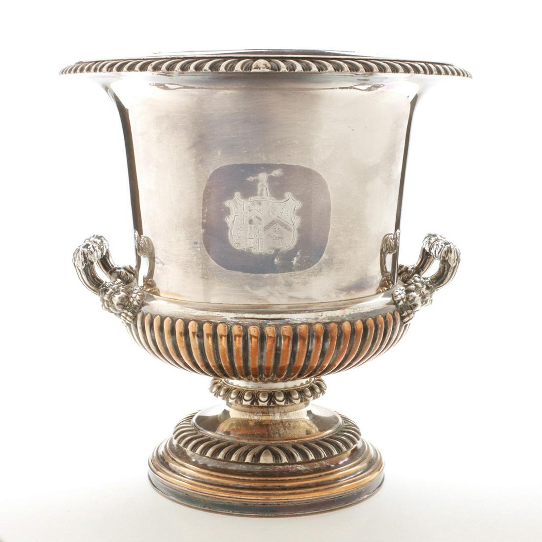 AN OLD SHEFFIELD PLATE WINE COOLER SIGNED CRESWICK: The campagna urn form cooler with removable drop-in liner enclosed at the rim by a gadrooned edge, an original hand engraved family crest on the front wall, lion figural handles, raised on a circular 