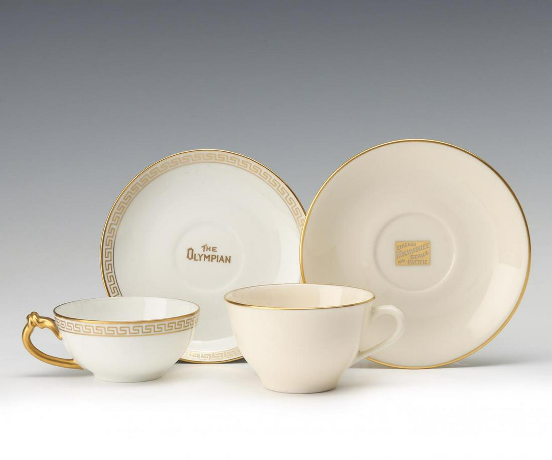 TWO CMStP&P RAILROAD 'OLYMPIAN' CUP AND SAUCER SETS: Two china cup and saucer sets for Chicago, Milwaukee, St. Paul and Pacific Railroad's Olympian passenger train: A cup and saucer with Greek keys on the rims, gold lettering inside the cup 'CMStP,' the