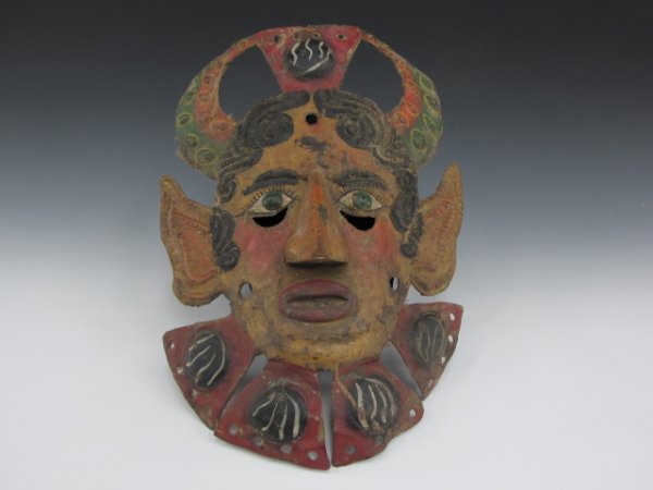 ALTIMIRANO GIERRERO MEXICAN CONQUISTADOR DANCE MASK: A circa 1900 polychrome painted copper mask with cut and embossed detail, green eyes. The devilish features seem to associate it with a conquistador dance. Measures 16 x 10.5 inches, chin cup and line