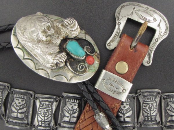 BEAR BOLO, BELT AND SILVER TOTEM BRACELET: Applied bear over inset turquoise and red stone, 2.25 x 1.5 inches, finials show some wear. Also a 9 facet .900 marked silver totem braclet with alternating figures, 52 grams, and a small ladies' belt