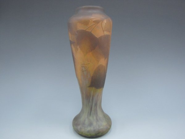 A DAUM NANCY CAMEO GLASS VASE: A French cameo glass vase cut with designs of Birch leaves in brown, against an internally decorated glass of amber and streaked with green mottled glass. Signed in cameo relief. Measures 12.5 inches