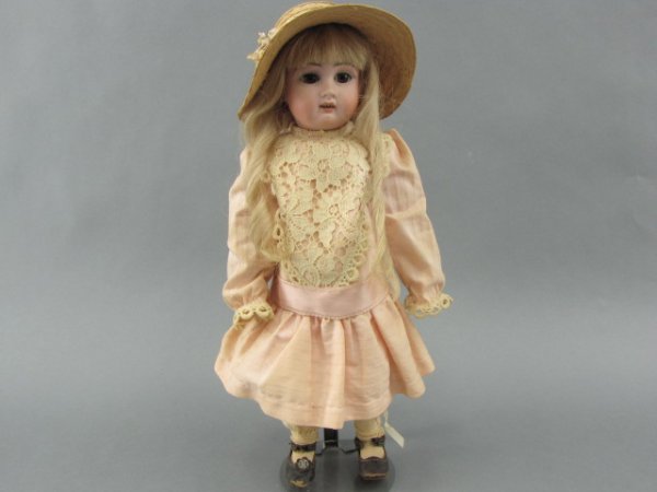 A JULLIEN FRENCH BISQUE DOLL: An antique French doll with socket head having impressed marks of JULLIEN 4, brown sleep eyes, wispy painted eyebrows, open mouth with teeth, pierced ears, ball jointed body, old costume, old shoes, c