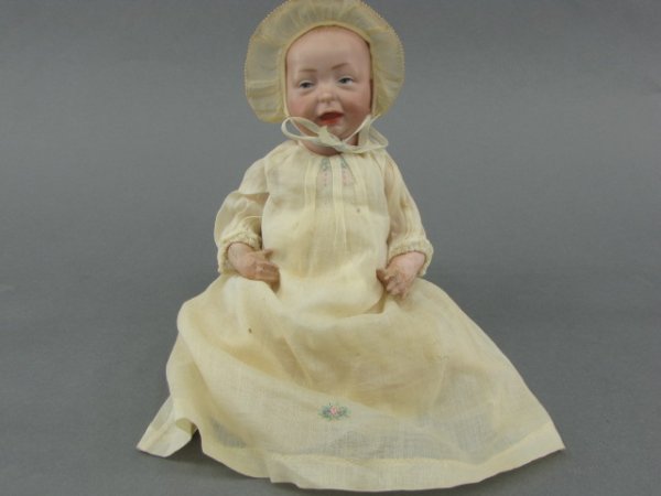 A K*R KAISER BABY DOLL: Molded bisque socket head with impressed marks of "28" over K and R on each side of Star of David, number 100 below. Composition body with bent limbs, measures 10.5 inches.
