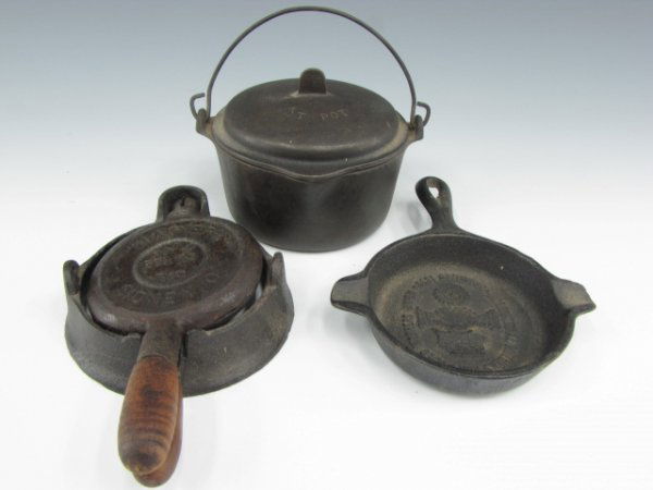 WAGNER MINIATURE KETTLE, DUTCH OVEN & WAFFLE IRON: Cast iron with lid, incised "Hot Pot" to top, Wagner Ware to bottom. Measures 3 x 4.5 inches. Includes wire handle. Lot also includes a Wagner waffle iron, patent dated 1910, and a skillet with emboss