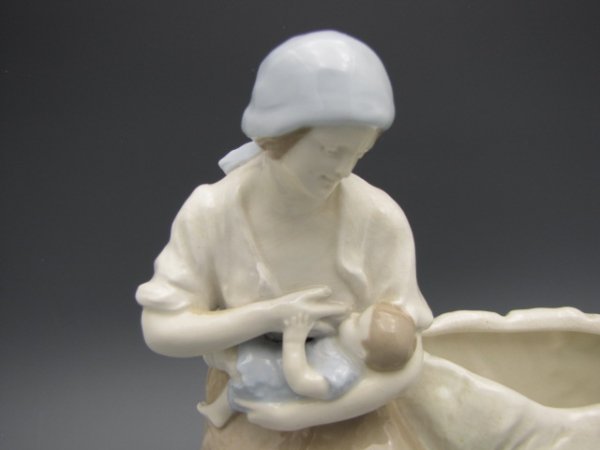 AN IMPERIAL AMPHORA CERAMIC SCULPTURE: Incised "Imperial, Amphora, Austria" to bottom, scene of woman feeding a baby next to a goat, measures 8.5 x 9 inches. Indistinct artist signature to reverse.