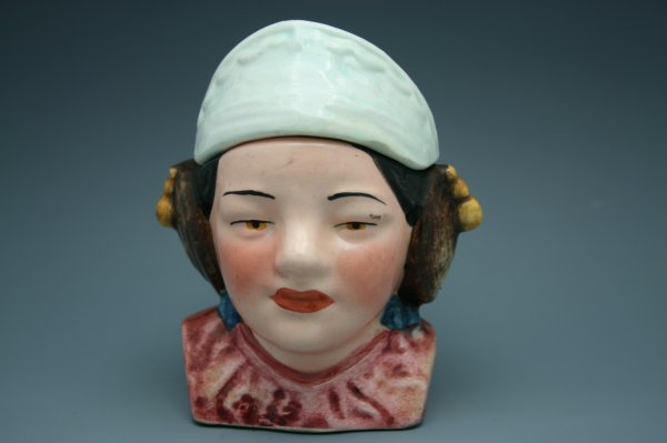 MAJOLICA FIGURAL HUMIDOR WITH ORIENTAL WOMAN: Nice Majolica humidor depicting an oriental woman with white headband, indistinct marks on bottom, measures 5 inches tall.