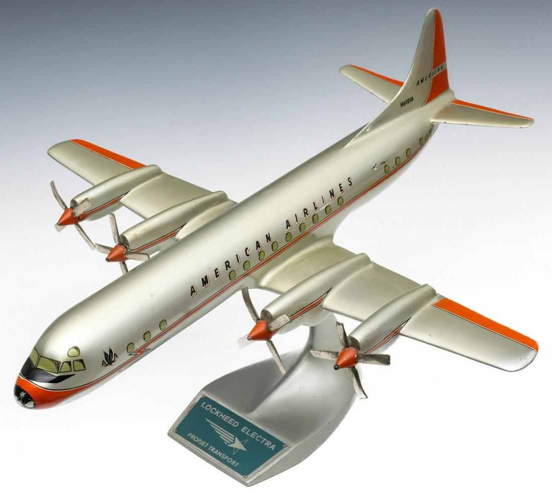 AN AMERICAN AIRLINES TRAVEL AGENT ADVERTISING MODEL: The painted aluminum scale model of a mid 20th century Lockheed Electra Propjet Transport prop driven airliner displayed on a painted aluminum swoosh-like stand with enameled badge lettered LOCKHEED E