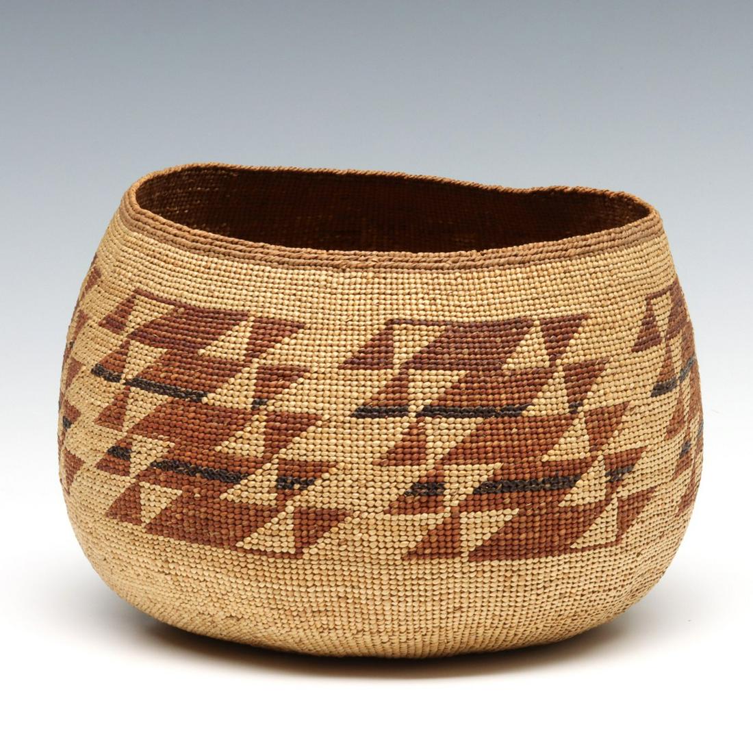 AN UNUSUALLY LARGE AND FINELY WOVEN HUPA BASKETRY HAT: The woven hat with hazelnut warp and finely split pine root weft in a twining technique. Both Hupa and Yurok women wore these woven basketry hats as 'dress hats' in their ceremonies. Regarded as a sta