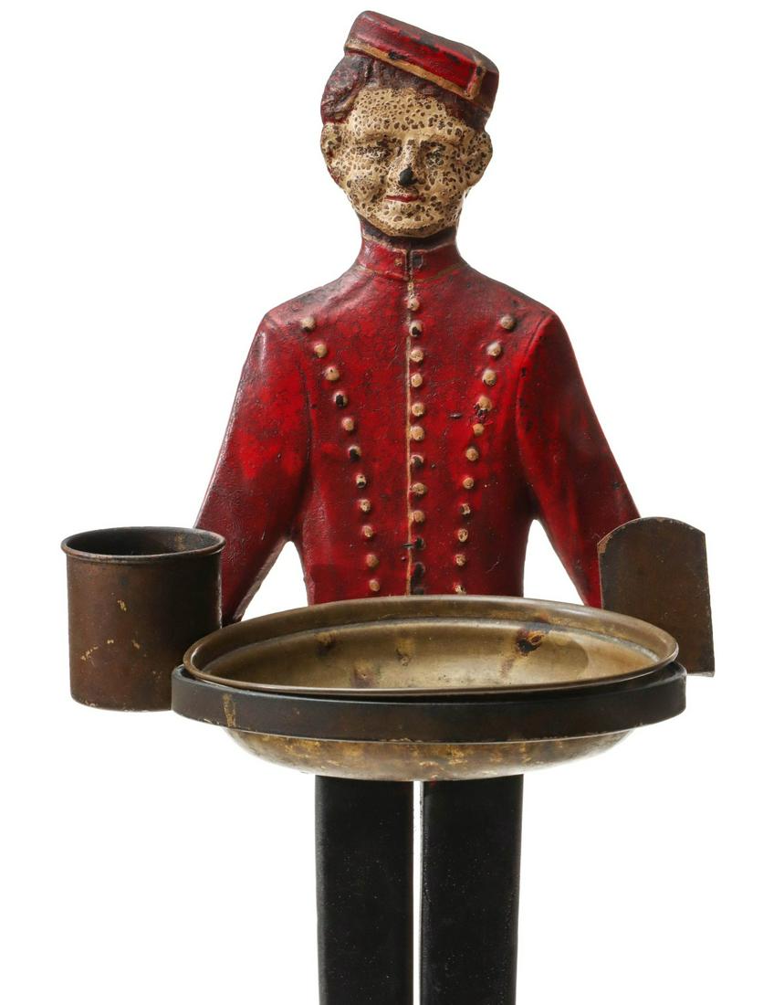 IRON JOHNNY PHILLIP MORRIS BELL BOY ASH RECEIVER C.: The floor standing cast iron Bell Boy ash receiver stand with brass tray, cigarette holder and matchbox stand may be based on Johnny Roventini, the real life popularly as Johnny Philip Morris, the 'li