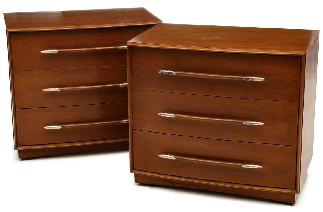 A PAIR ROBSJOHN GIBBINGS BACHELOR CHESTS FOR WIDDICOMB: The walnut case with platform base, outset trim framing three drawers with long bow-shaped pulls tipped in streamlined brass caps with silver or nickel plating, signed inside the divided top drawer. M