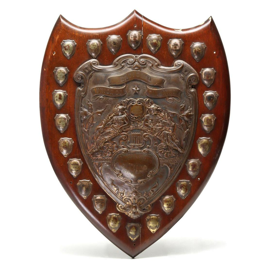 A NATIONAL UNION OF RAILWAYMEN WHIST CHAMP PLAQUE: The oak shield-form whist trophy with ornate cast brass applications. including the large central shield with top banner with hand engraved lettering of NATIONAL UNION OF RAILWAYMEN, the inset is engr