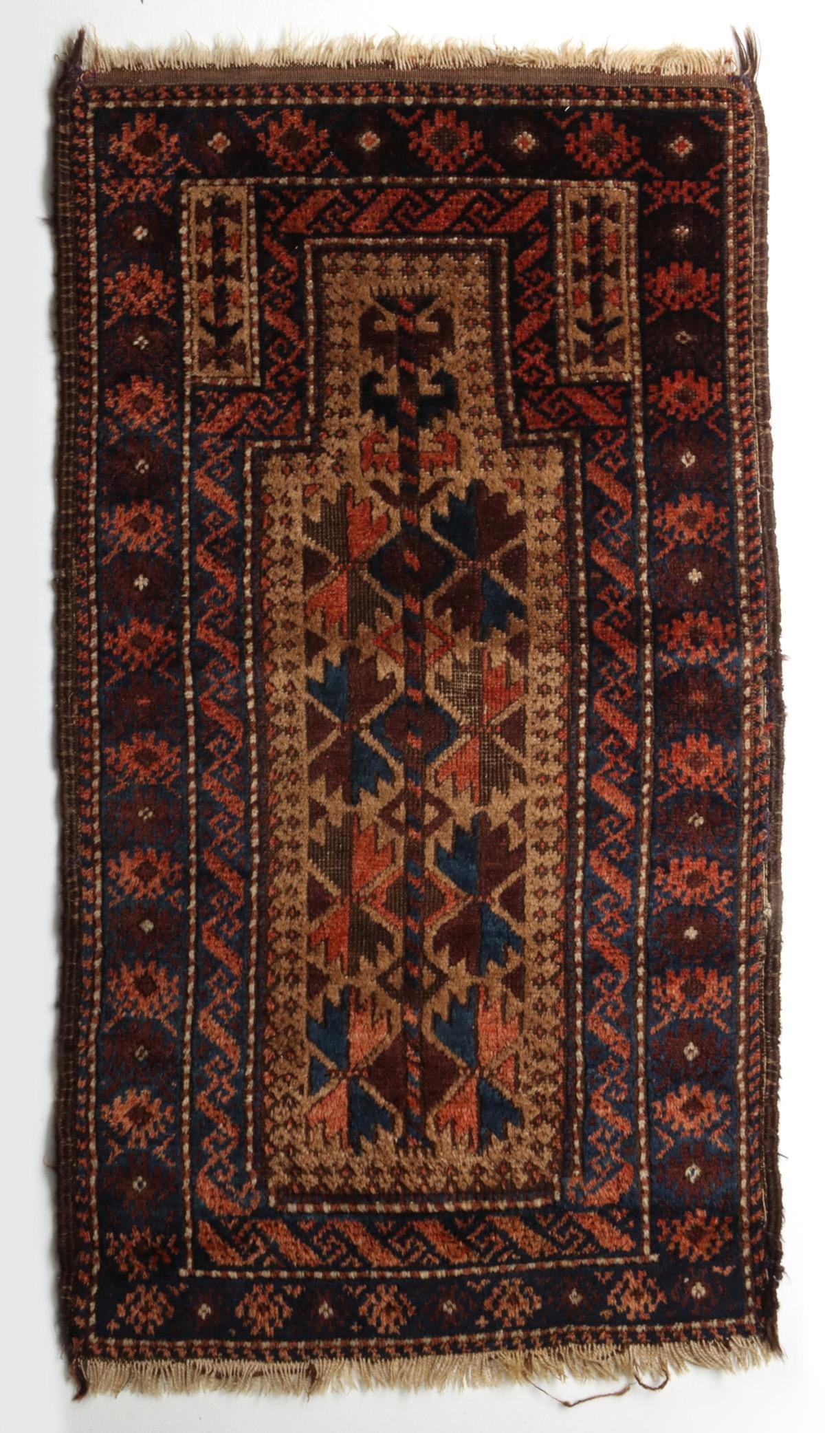 A GOOD ANTIQUE BALOUCH PRAYER RUG: The nice example in small size with an interesting guard border immediately surrounding the mihrab with camel ground. Measures 40 x 21 inches. We happily provide seamless in-house packing and shipping