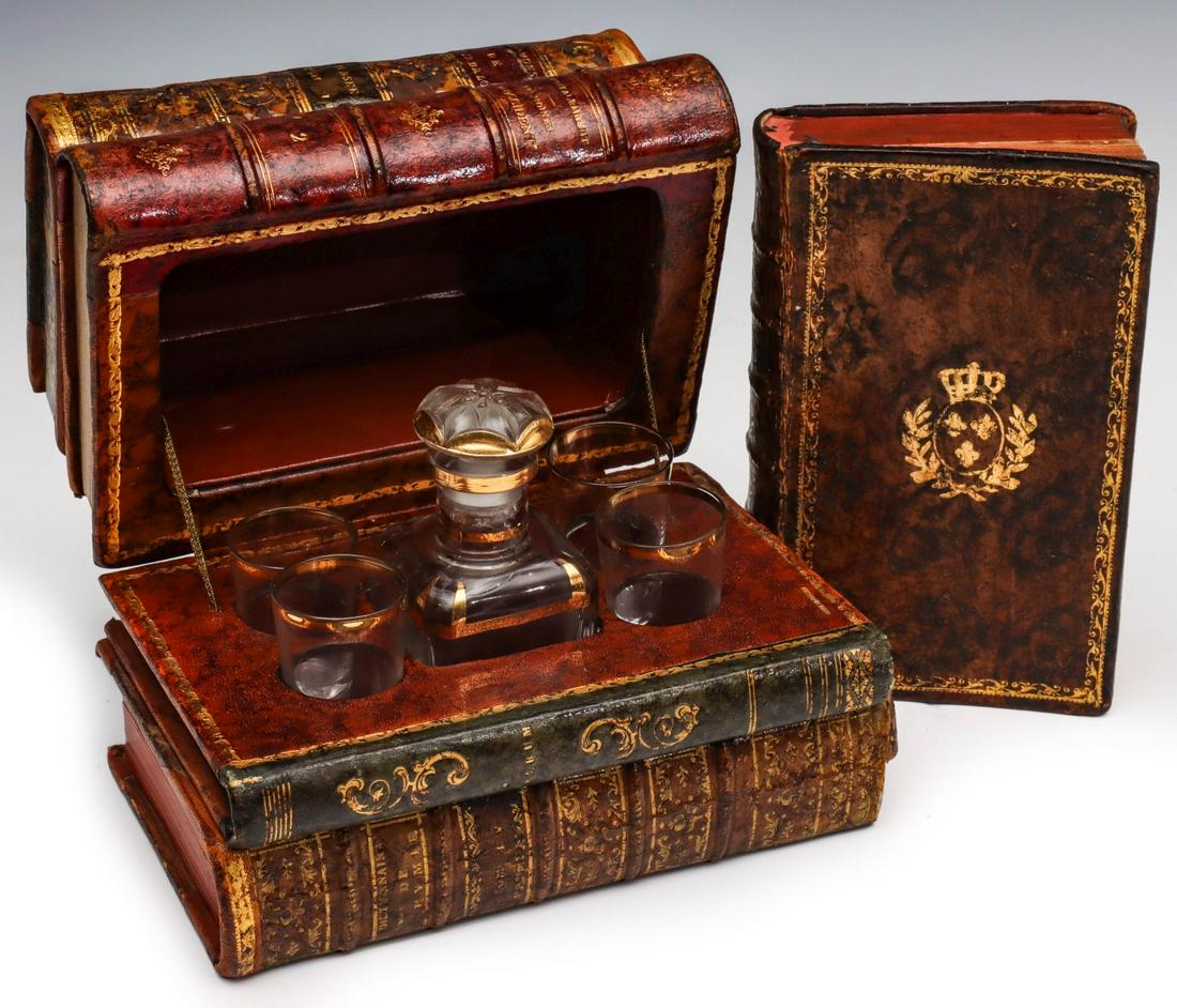 FAUX ANTIQUE LEATHER BOOK LIQUEUR SET AND HIDDEN BOX: The faux leather book box with hinged lid and interior compartment for a liqueur bottle with four shot glasses. Plus an antique leather book with hidden compartment. Box measures 5.25 x 7.25 x 4.5 inc