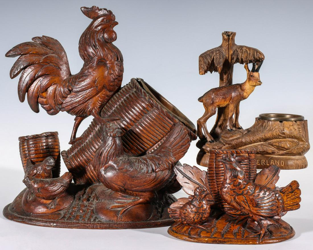THREE EARLY 20TH C. BLACK FOREST WOOD CARVINGS: A really nice grouping lead by. 1. Cigar and cigarette holder topped by a cockerel on baskets above a hen with chicks and a smaller basket. 2. Carving of a hen and chick on oval base with basket and l