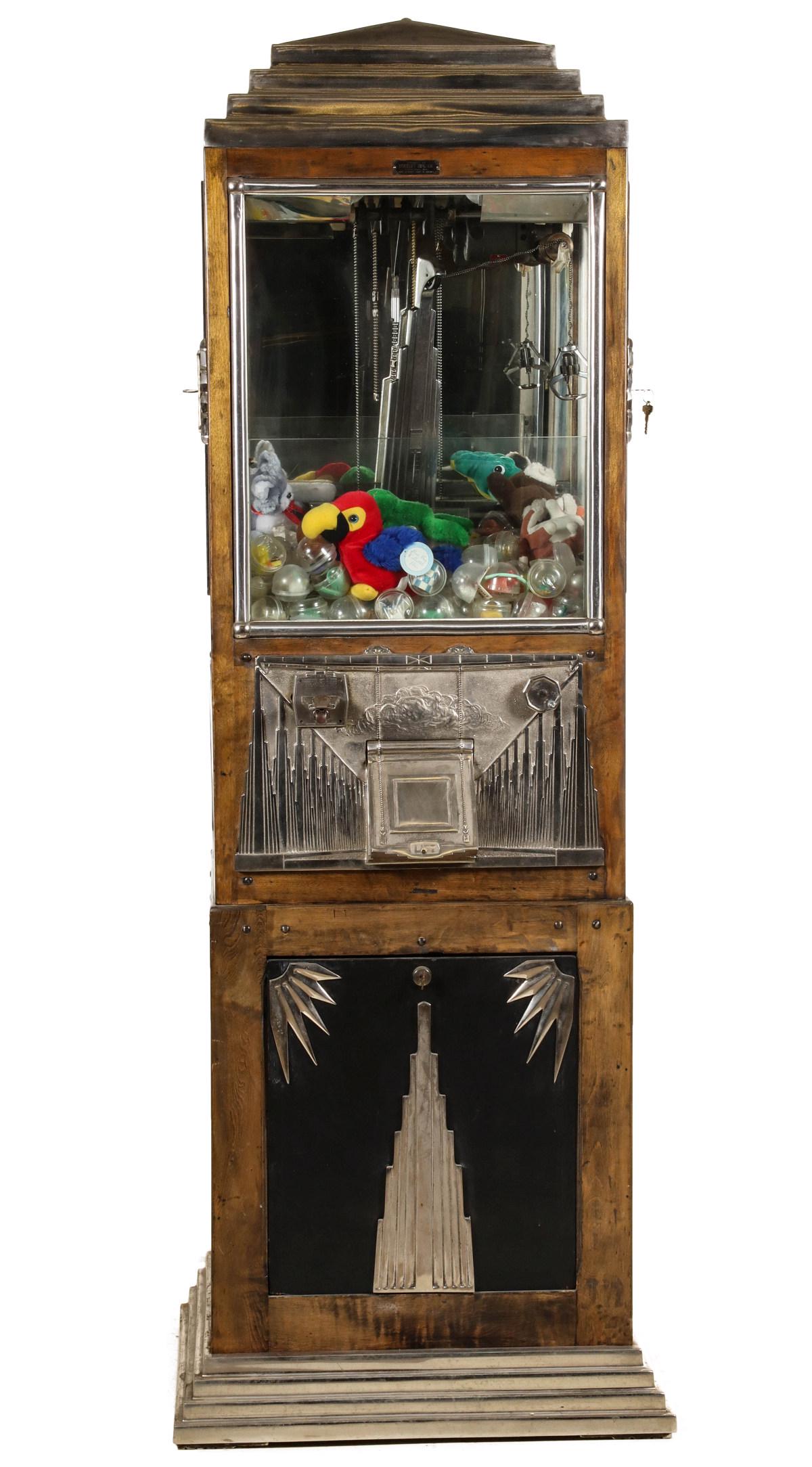 A BUCKLEY MFG ART DECO COIN OPERATED ARCADE DIGGER: The Art Deco tower-form case with great design is topped by a stepped iron cap with nickel plating over the glass case and digger apparatus, half-round nickeled glass framing accented by applied decor
