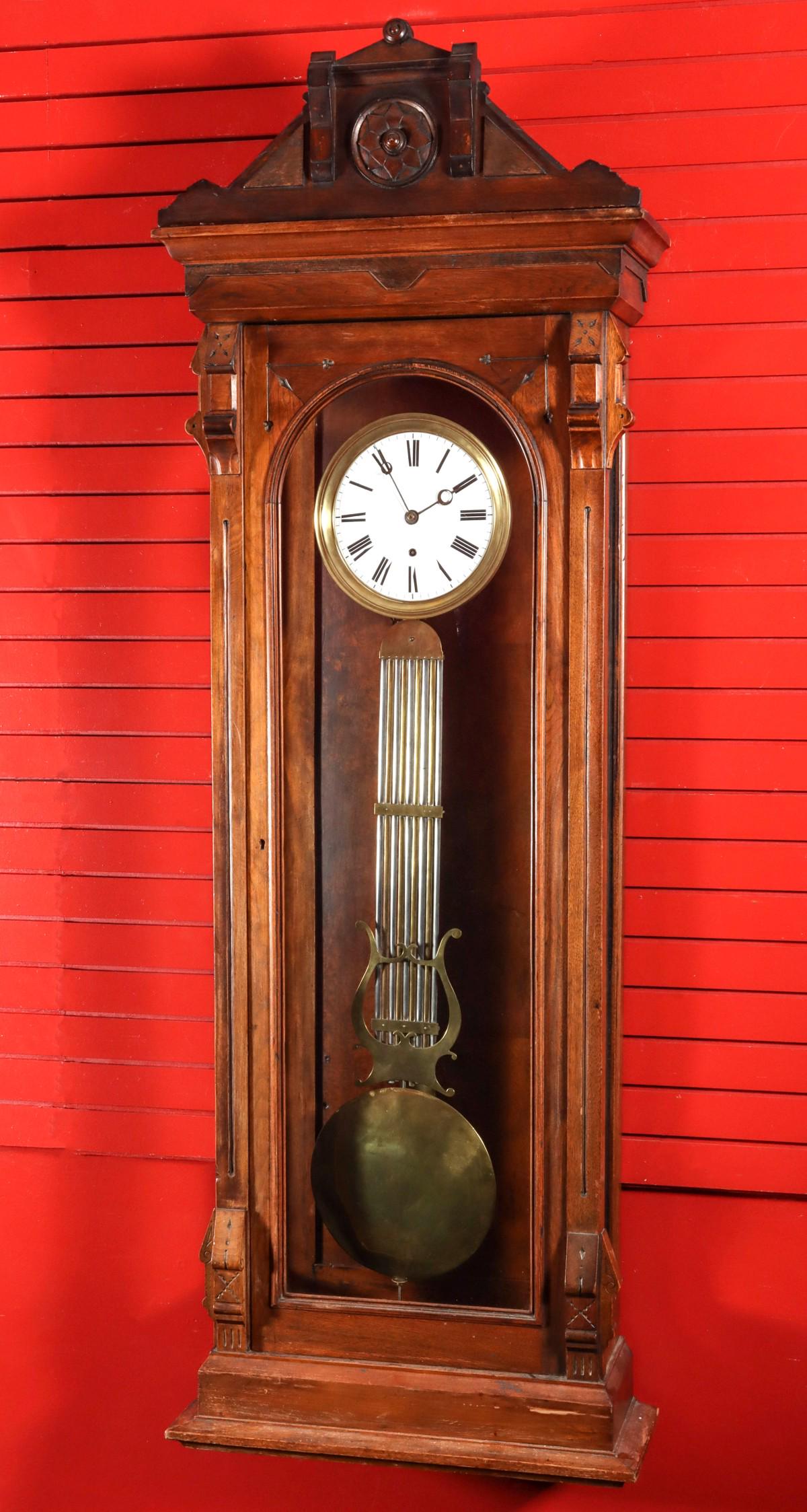 A 19TH C. JEWELER'S REGULATOR CASE W/ PINWHEEL MOVEMENT: The 19th century American hardwood clock case fitted with a time only pinwheel clock movement fronted by a porcelain enamel dial in brass bezel with hand painted Roman numeral chapter ring and two-ton