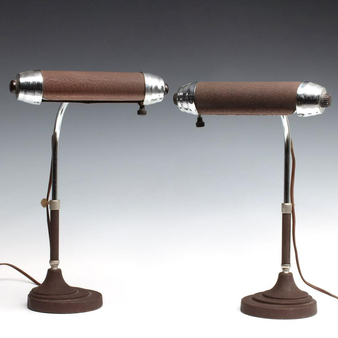 A PAIR CIRCA 1940 ART DECO BULLET LAMPS: The cylindrical shade of each with stepped cap on either end of the crinkle finish shade raised on a rounded telescoping chrome support rod on offset base with concentric rings. Measure 13 x 9 inches.