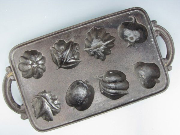 A FINE CAST IRON HARVEST MUFFIN PAN: All different designs; leaves, fruits, measures 16 x 8 inches.